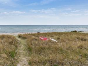 Store FugledeにあるHoliday Home Saija - 100m from the sea by Interhomeの浜辺の草むらに停泊しているボート