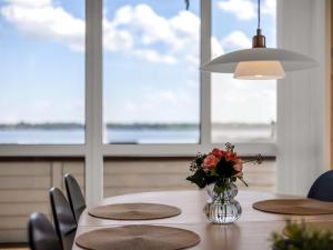 a dining room table with a vase of flowers on it at Holiday Home Jelke - 500m from the sea by Interhome in Aabenraa