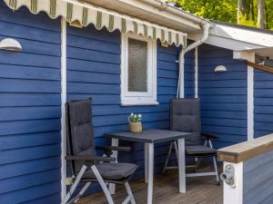 a blue house with a table and chairs on a deck at Holiday Home Jelke - 500m from the sea by Interhome in Aabenraa +21 photos
