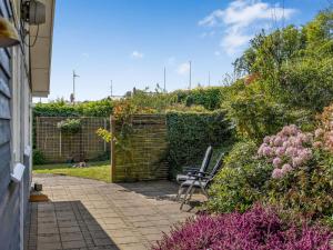 a patio with two chairs in a garden at Holiday Home Jelke - 500m from the sea by Interhome in Aabenraa