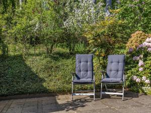 two chairs sitting next to each other in a garden at Holiday Home Jelke - 500m from the sea by Interhome in Aabenraa