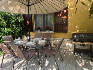 a table with chairs and an umbrella on a patio at Mia's House on Lake Garda in Sirmione