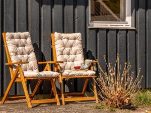 two rocking chairs sitting next to a building at Holiday Home Bara - from the sea by Interhome in Hadsund +18 photos