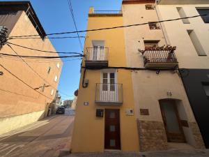 a yellow building with two balconies on a street at Lo Corner House in Móra d'Ebre