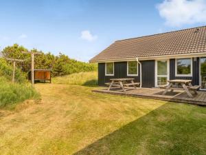 a house with a deck and a picnic table at Holiday Home Eftim - 500m from the sea by Interhome in Harboør