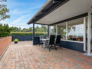 a patio with glass doors and a table and chairs at Holiday Home Atena - 200m from the sea by Interhome in Hals