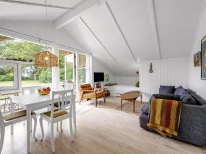 a living room with a table and a couch at Holiday Home Nnykka - 125m from the sea by Interhome in Gørlev