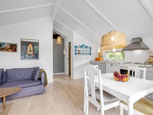 a kitchen and living room with a table and a couch at Holiday Home Nnykka - 125m from the sea by Interhome in Gørlev