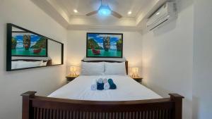 une chambre avec un lit avec deux chaussures dessus dans l'établissement Palace - Spacious 1 bedroom Condo with shared Pool, à Patong Beach 25 autres photos