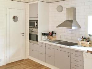 a kitchen with white cabinets and a stove top oven at 4 star holiday home in Sölvesborg in Hällevik