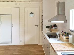 a kitchen with white cabinets and a sink at 4 star holiday home in Sölvesborg in Hällevik