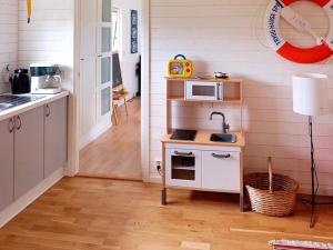a kitchen with a small table and a microwave at 4 star holiday home in Sölvesborg in Hällevik +23 photos