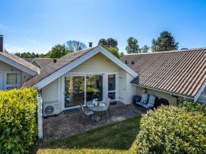 a house with a patio with a table and chairs at Holiday Home Darina - 150m from the sea by Interhome in Askeby