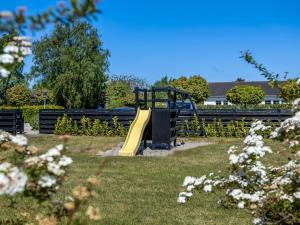 a playground with a slide in a park at Holiday Home Darina - 150m from the sea by Interhome in Askeby