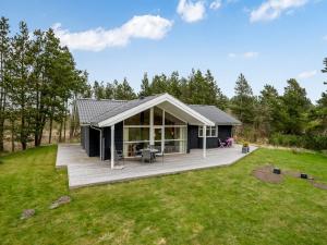 a house with a large deck in a yard at Holiday Home Teija - 600m to the fjord by Interhome in Skjern