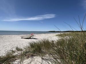 a chair sitting on a beach next to the ocean at Holiday Home Fridborg - 425m from the sea by Interhome in Holmstrup