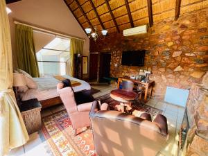 a hotel room with a bed and a stone wall at Pretoria Mansion Boutique Hotel Coral Tree in Pretoria