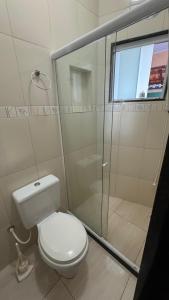 Un baño con inodoro y ducha de cristal. en Morada dos Anjos, en Arraial do Cabo