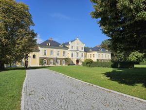 une grande maison avec une route pavée en face de celle-ci dans l'établissement Apartmán U Zámku - Self Check in - Airport OSR Mosnov, à Studénka