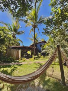 a hammock in front of a house at Pousada Habitat Caraíva in Caraíva