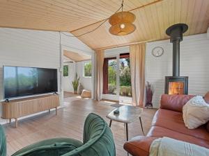 a living room with a couch and a flat screen tv at Holiday Home Oona - 700m from the sea by Interhome in Vordingborg