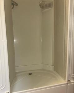 a white shower with a glass door in a bathroom at De Middendijk in Damme