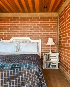 a bedroom with a bed with a brick wall at Chalet nas Nuvens with Infinity Pool in São Bento do Sapucaí +79 photos
