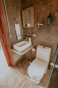 a bathroom with a white toilet and a sink at Chalet nas Nuvens with Infinity Pool in São Bento do Sapucaí +79 photos