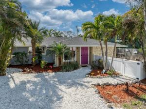 a house with palm trees and a pink door at Ocean72 Holmes Beach Vacation Home with Private Pool & hot tub & Walk-to-Beach Access in Holmes Beach