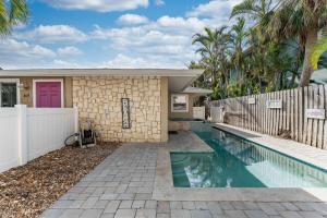 a house with a swimming pool next to a fence at Ocean72 Holmes Beach Vacation Home with Private Pool & hot tub & Walk-to-Beach Access in Holmes Beach