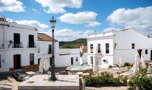 a courtyard with white buildings and a street light at CASA RURAL SANTA ELENA in Cazalla de la Sierra