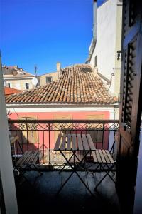 un balcone con panchina di fronte a un edificio di FLI I n' II Family Listed Inn since 1850 a Nauplia