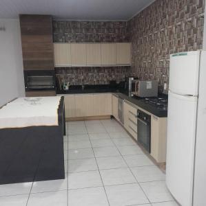 a kitchen with a white refrigerator and a white tile floor at Comfort and Style White Queen II in Cuiabá