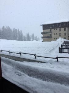 a road covered in snow next to a building at Ski en 5 secondes! in Val Cenis