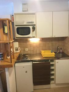a kitchen with a microwave and a stove top oven at Ski en 5 secondes! in Val Cenis