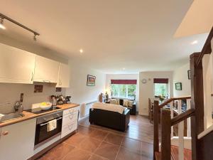 a kitchen and living room with a couch and a table at 93 Clifden Glen family friendly cottage in Clifden