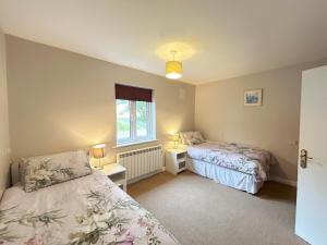 a bedroom with two beds and a window at 93 Clifden Glen in Clifden