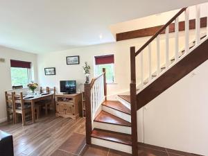 a staircase in a living room with a table and a desk at 93 Clifden Glen family friendly cottage in Clifden