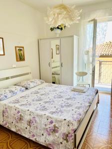 ein Schlafzimmer mit einem großen Bett und einem Kronleuchter in der Unterkunft Domus Eleonora tra Laghi e Malpensa MXP in Sesto Calende