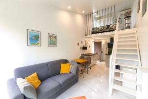 Una sala de estar con un sofá azul y una escalera. en Studio with sea view, en Orcino