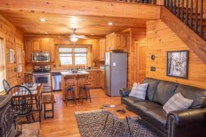 a living room and kitchen with a leather couch in a cabin at West Jefferson Cabin- Hot Tub, Fireplace, Sleeps 7 in West Jefferson