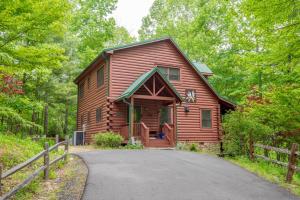 a log cabin in the woods with a driveway at West Jefferson Cabin- Hot Tub, Fireplace, Sleeps 7 in West Jefferson