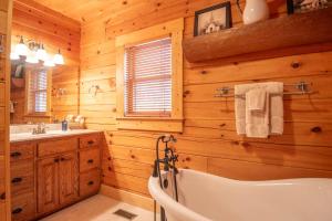 a wooden bathroom with a tub and a sink at West Jefferson Cabin- Hot Tub, Fireplace, Sleeps 7 in West Jefferson +29 photos