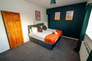a bedroom with a bed and a wooden door at Cosy 3-Bed Swansea Home near City & Bay in Swansea