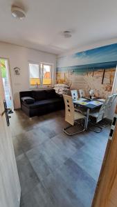 una sala de estar con una mesa y un sofá en Domki Tyfami - Dom 3, en Jarosławiec