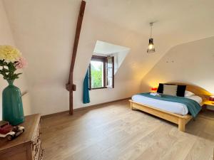 a bedroom with a bed and a vase of flowers at La Maison Bretonne in Chartres-de-Bretagne
