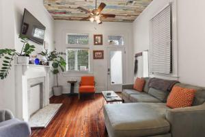 a living room with a couch and a fireplace at Heart of MidCity Front Porch 3bd 2 bath Streetcar in New Orleans
