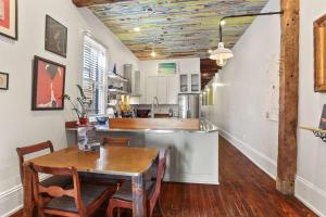 a kitchen with a wooden table and a dining room at Heart of MidCity Front Porch 3bd 2 bath Streetcar in New Orleans