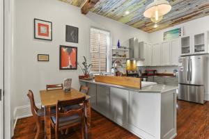 a kitchen with a table and a kitchen with a refrigerator at Heart of MidCity Front Porch 3bd 2 bath Streetcar in New Orleans +17 photos