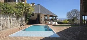 a swimming pool in front of a house at Cabañas 57 in Villa Carlos Paz